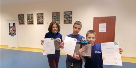 Powiększ grafikę: Hania, Wojtek i Kacper prezentują nagrody i dyplomy zdobyte w konkursie Zakodowany Konkurs Walentynkowy.Dzieci ubrane są w koszulki CMI.