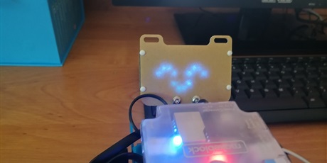 Powiększ grafikę: Symbol "uśmiechniętego robota" wyświetony na LED robota mBot.