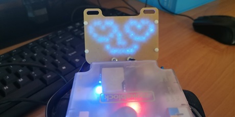 Powiększ grafikę: Symbol "uśmiechniętego robota" wyświetony na LED robota mBot.